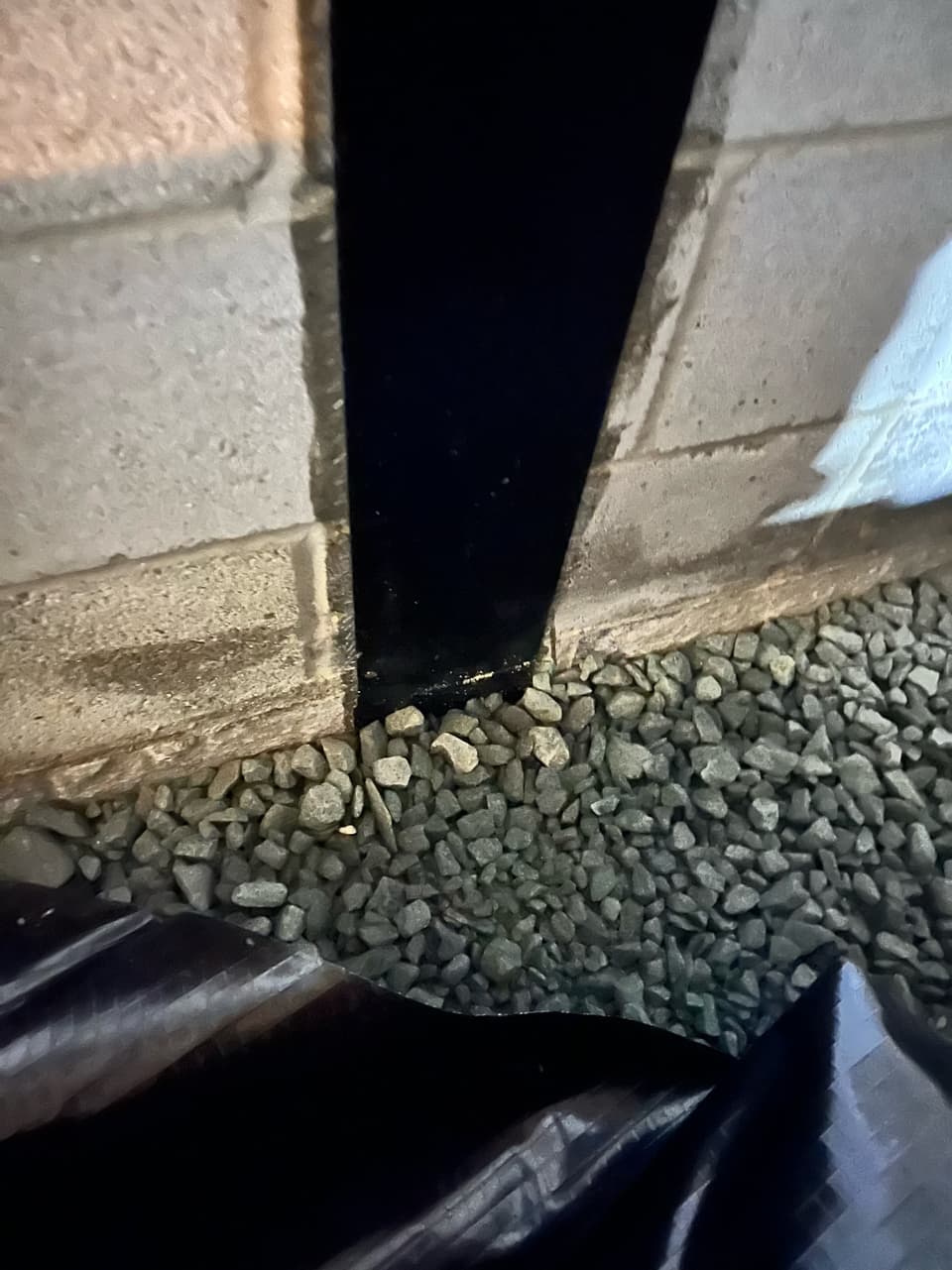 Gravel and barrier at the base of the wall carrying water to drainage