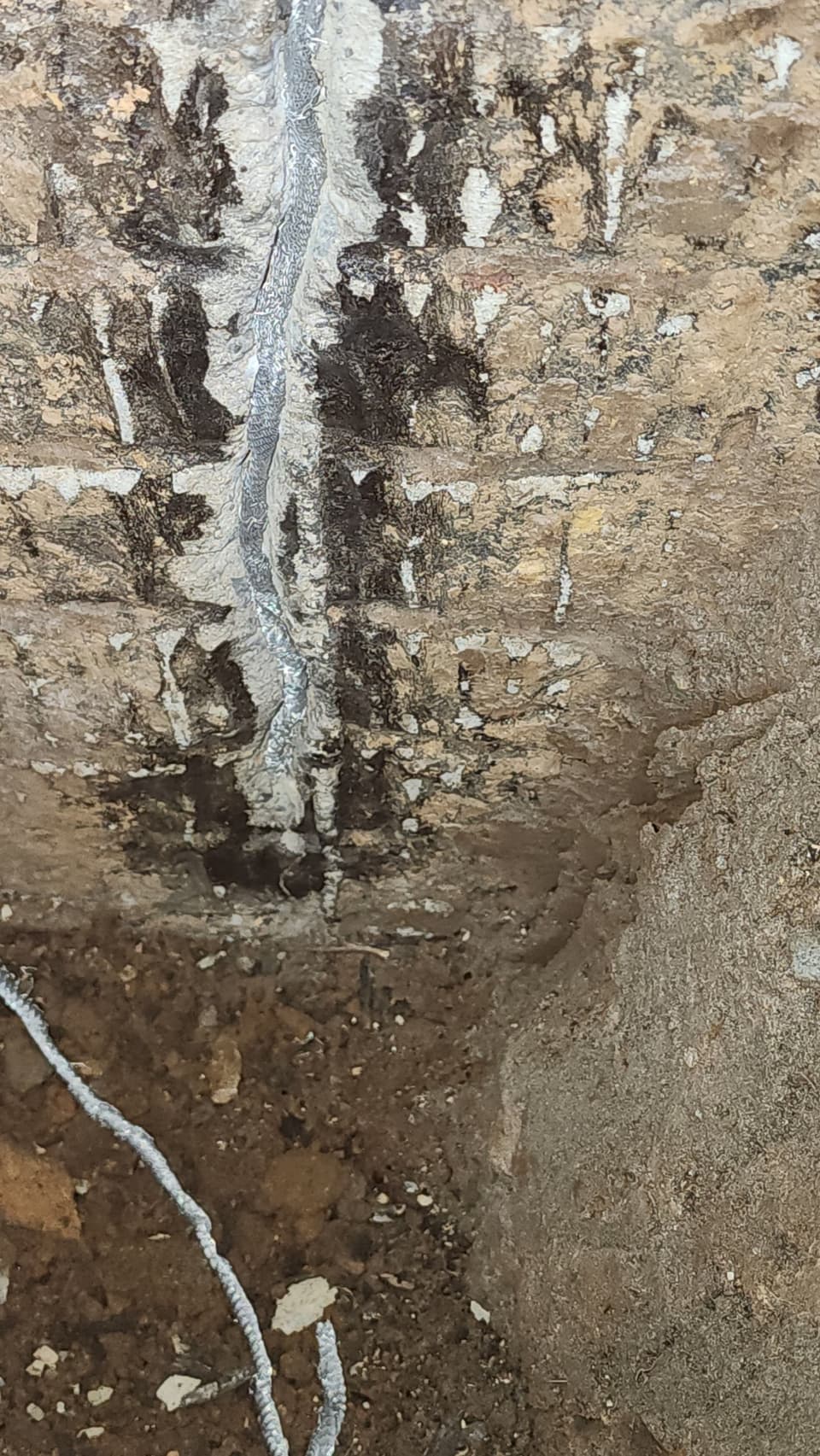 Vertical crack in a block foundation wall with signs of water intrusion